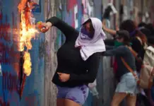 Mexico City police contain protesters who were trying to damage businesses during the March 8th demonstrations in Mexico City